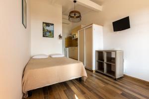 a small bedroom with a bed and a television at La Punta Geronimi in Porto Pollo