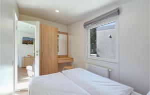 a bedroom with a white bed and a window at Tiny Haus 67 Am Brombachsee in Pleinfeld
