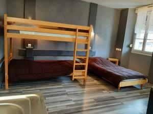 オルナンにあるHôtel de La Valléeのベッドルーム1室(二段ベッド2台、はしご付)