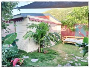 a white shed with a bench in a yard at LA CABANE D'artiste in Cul de Sac