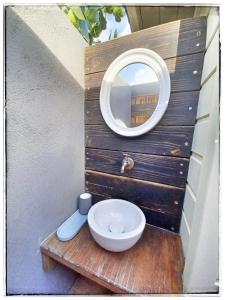 a bathroom with a mirror and a toilet on a table at LA CABANE D'artiste in Cul de Sac