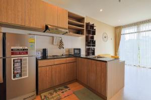 - une cuisine avec des placards en bois et un réfrigérateur dans l'établissement Park Town Residence, à Ban Rangeng