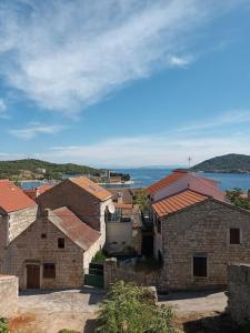 a group of brick buildings with the ocean in the background at Studio apartman Tomi - seaview in Vis