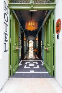 un corridoio con porte verdi e pavimento a scacchi di La Maison d'été a Salon-de-Provence