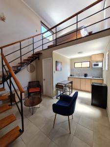 a living room with a staircase and a kitchen at Cabañas y Loft Parronal in Vicuña