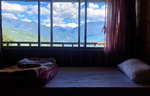 a room with a window with a view of mountains at Phamlhakhang Ecohomestay in Pelling