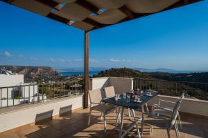 een tafel en stoelen op een balkon met uitzicht bij Lenikos Resort in Agia Galini