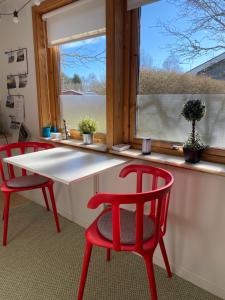 a kitchen with two red chairs and a table and a window at 3:e Sandbank in Beddinge Strand