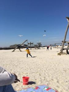 eine Gruppe von Menschen, die am Strand spielen in der Unterkunft Gästezimmer Lütje Wattwurm in Dornumersiel