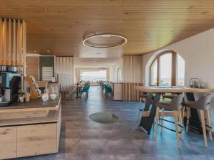 a kitchen with wooden ceilings and tables and chairs at Weingut & Gästehaus zum Seeblick - Familie Sattler in Jois