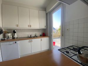 een keuken met witte kasten en een fornuis met oven bij Panchika in Oostduinkerke
