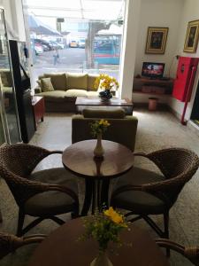a living room with tables and chairs and a couch at Dublin Hotel in Sao Paulo