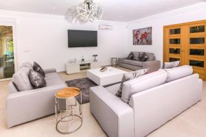 ein Wohnzimmer mit zwei Sofas und einem Fernseher in der Unterkunft Casa Juana is a modern, luxury, exclusive, 6 bedroom villa. in Jávea