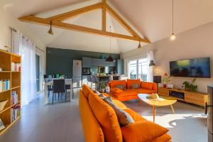 - un salon avec un canapé orange et une table dans l'établissement Charmante maison avec Vue LAC et Montagnes - PISCINE privative - LLA Selections by Location lac Annecy, à Saint-Jorioz