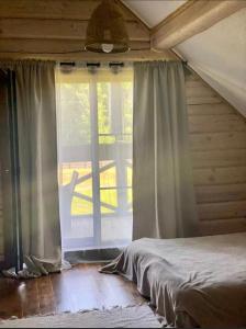 a bedroom with a bed and a large window at Vila Dona in Varėna