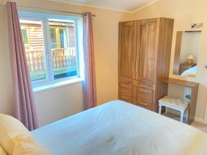 a bedroom with a bed and a window at Dalis Den Lodge in Bridlington
