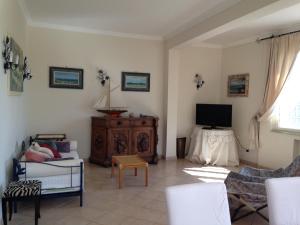 a living room with a couch and a tv at Villino dei Coralli in Lido di Ostia
