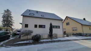 a white house with a black roof at Apartment_BaLi in Linkenheim-Hochstetten