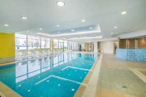 una gran piscina en el vestíbulo del hotel con una gran ventana en MF Club 218 Palazzo Wellness Apartment en Siófok
