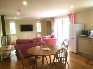un soggiorno con divano rosa e tavolo di Treweens a Wadebridge