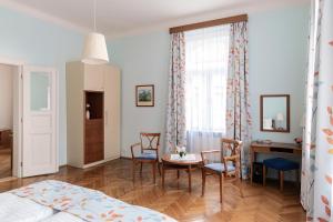 - une chambre avec un lit, une table et des chaises dans l'établissement Sibelius Apartments, à Prague