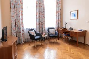 ein Zimmer mit Stühlen und einem Schreibtisch und einem Fenster in der Unterkunft Sibelius Apartments in Prag