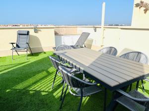 un tavolo e sedie su un patio con prato di Ático de lujo - Luxury Penthouse a Huelva