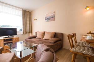 a living room with a couch and a glass table at Apartmenthaus Frauenpreis FeWo 205 in Cuxhaven