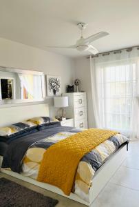 una camera con un letto con una coperta gialla di Ático de lujo - Luxury Penthouse a Huelva