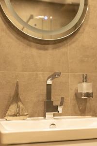 een wastafel in een badkamer met een spiegel en een wastafel bij Kadir Bey & Four Rooms in Osterrönfeld