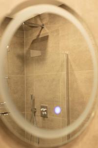 Blick auf eine Dusche durch einen runden Spiegel in der Unterkunft Kadir Bey & Four Rooms in Osterrönfeld