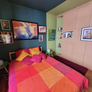 um quarto com uma cama com um cobertor colorido em L'Atelier Bed and Breakfast em Andrimont