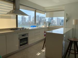 a kitchen with white cabinets and a view of the city at Bukit Bintang Fairlane Residences Twin Towers View in Kuala Lumpur