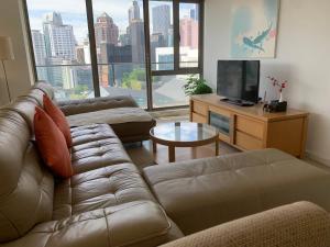 a living room with a couch and a tv at Bukit Bintang Fairlane Residences Twin Towers View in Kuala Lumpur