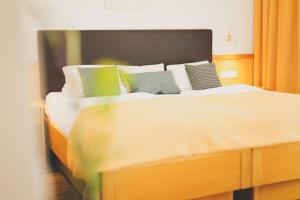 A bed or beds in a room at Weingut & Gästehaus zum Seeblick - Familie Sattler