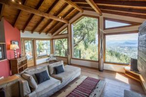 sala de estar con sofá grande y ventanas grandes en Casa Karine - Vue imprenable et dolce vita en San Carlos de Bariloche