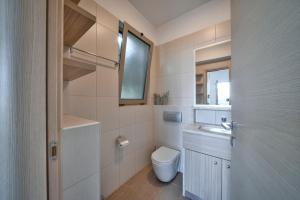 a bathroom with a toilet and a sink and a window at Lenikos Resort in Agia Galini