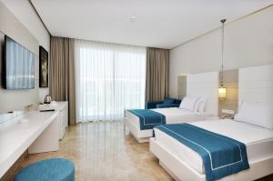 a hotel room with two beds and a bathroom at Lugga Boutique Hotel & Beach in Ortakent