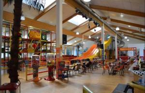a restaurant with tables and chairs and a slide at Bergerlebnis Natur pur in Sankt Englmar