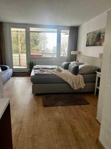 - une chambre avec un lit et une grande fenêtre dans l'établissement Bergerlebnis Natur pur, à Sankt Englmar