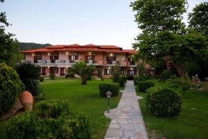 a large house with a pathway in front of it at Stamos Apartments and Studios in Vourvourou +24 photos