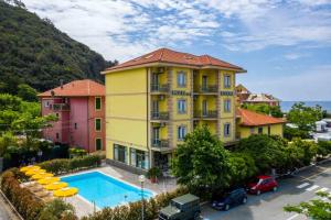 un grande edificio giallo con una piscina di fronte di Hotel Riviera a Deiva Marina