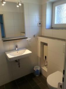 a bathroom with a sink and a toilet and a mirror at Ferienreihenhaus D, Ostseebad Dahme in Dahme