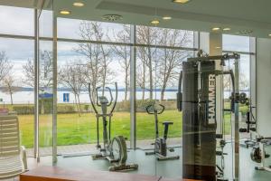 a gym with a large window and tread machines at MyFlat Club 218 Golden Beach Wellness Apartment in Siófok