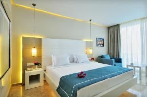 a bedroom with a large bed with a blue blanket at Lugga Boutique Hotel & Beach in Ortakent