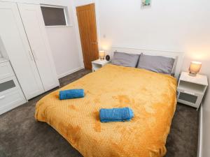 um quarto com uma cama com duas almofadas azuis em Lauristine Flat em Penzance