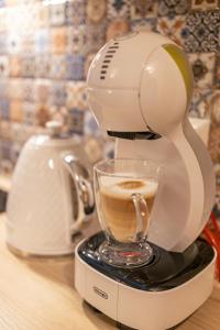 a coffee maker on a counter with a cup of coffee at Villa Kasztelan Apartamenty in Ustrzyki Dolne