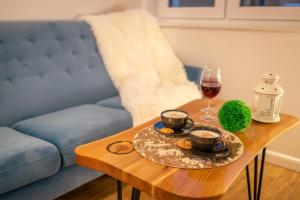 stolik kawowy z dwoma kubkami i kieliszkiem wina w obiekcie Villa Kasztelan w mieście Ustrzyki Dolne