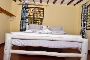 a white bed in a room with a window at Private room in a villa in Diani Beach