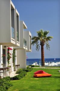 a house with a red object on the grass next to a palm tree at Lugga Boutique Hotel & Beach in Ortakent